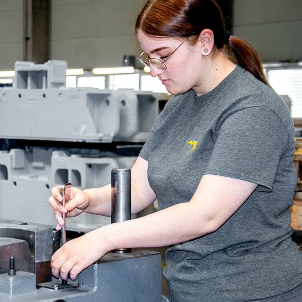 Eine junge Werkzeugbautechnikerin montiert in ihrer Lehre in Steyr bei weba Werkzeugbau Stanzwerkzeuge.